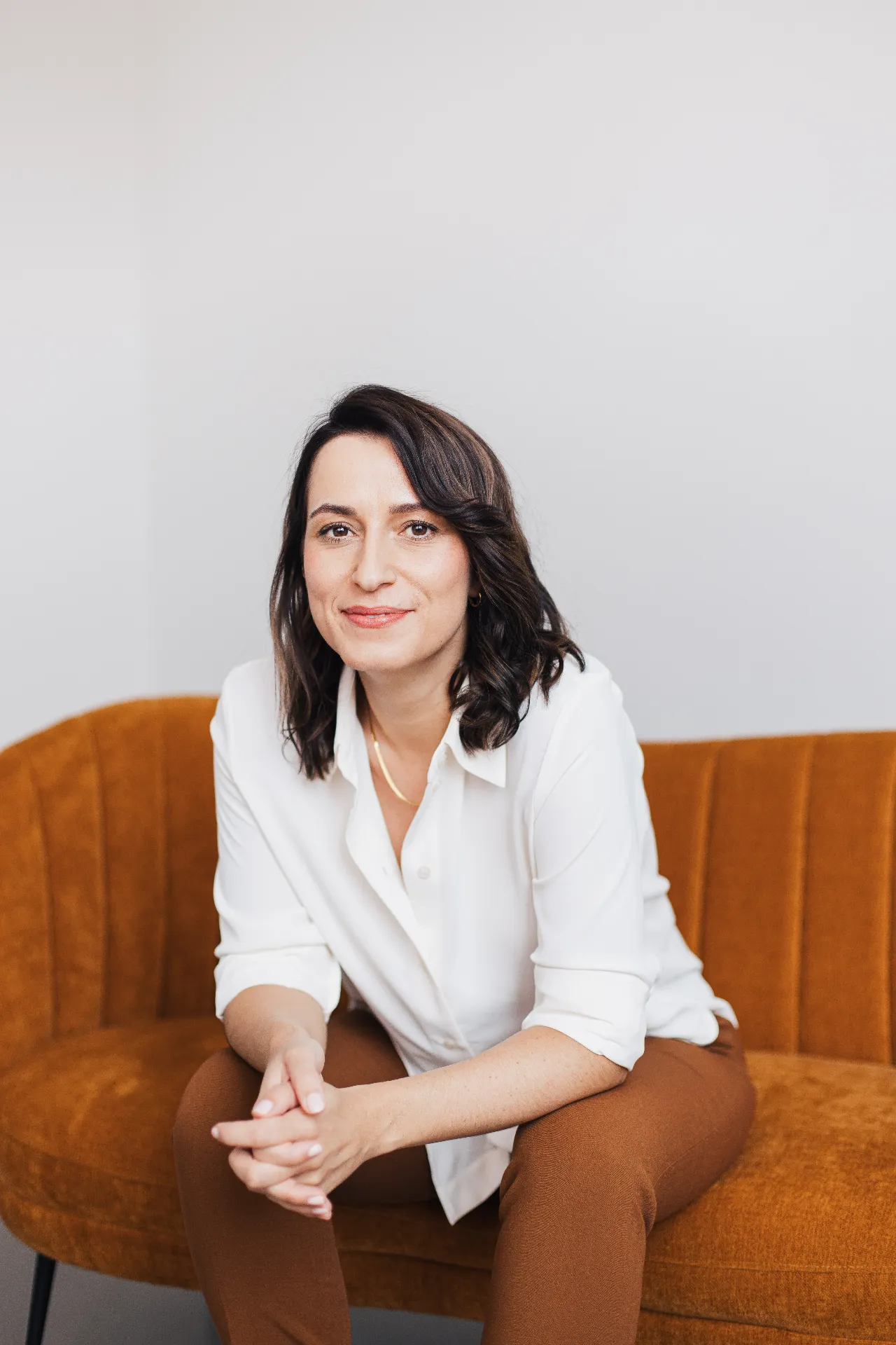 Madeleine Maßmann, Expertin für die Kinderfrage und zertifizierte Coachin, lächelnd auf einem Sofa sitzend